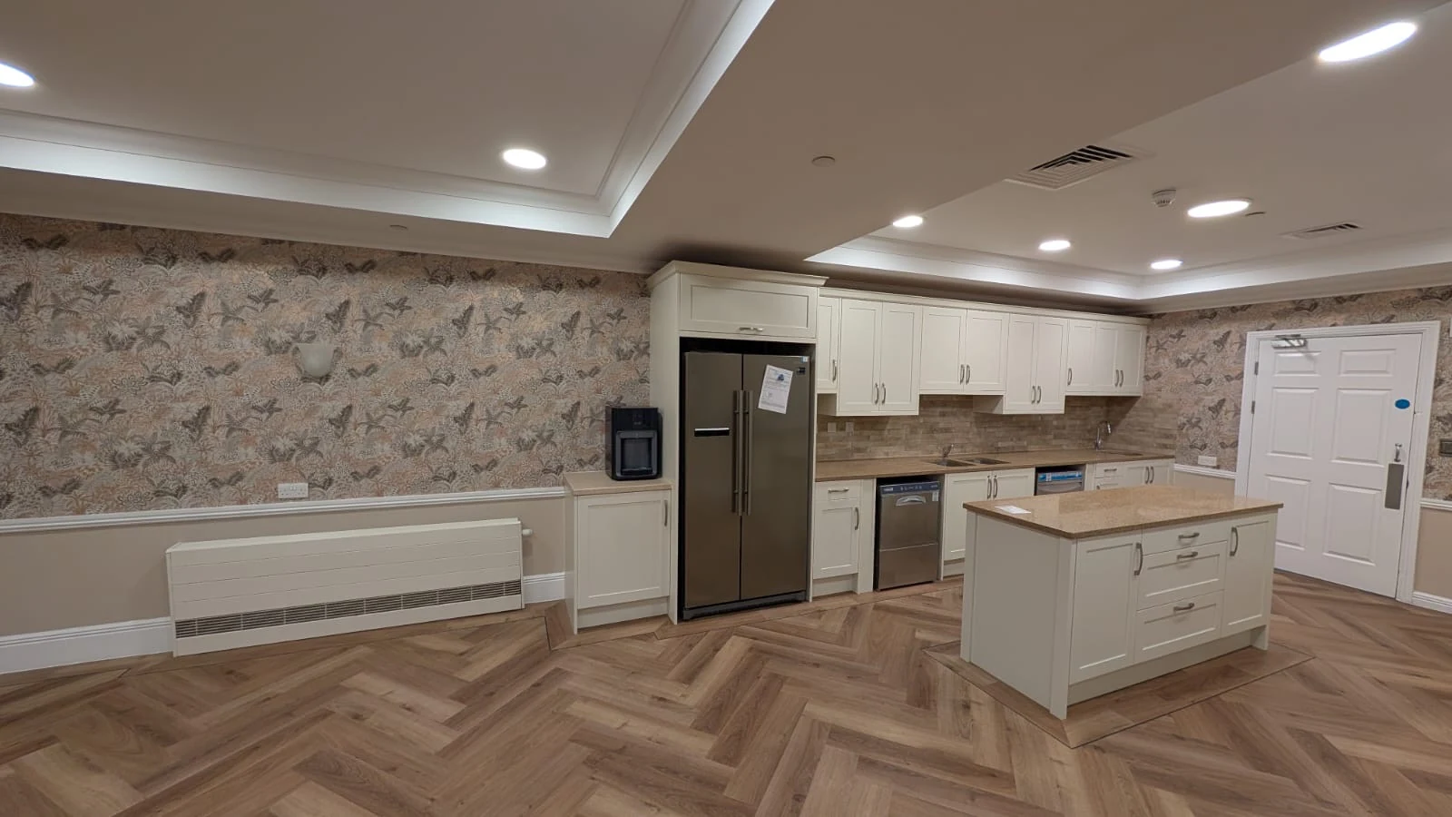 Completed Virginia Waters kitchen with cream cabinetry, central island and retained granite worktops