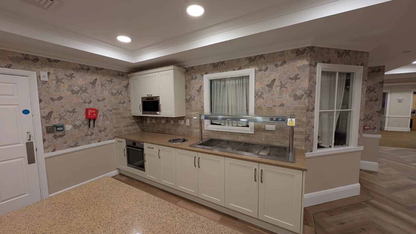 New servery cabinetry fitted beneath the retained granite worktop and existing serving equipment
